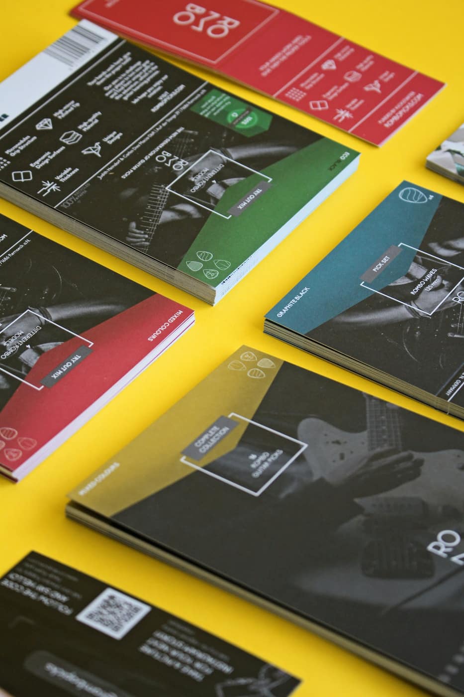 Stacks of colourful printed product cards on a yellow surface