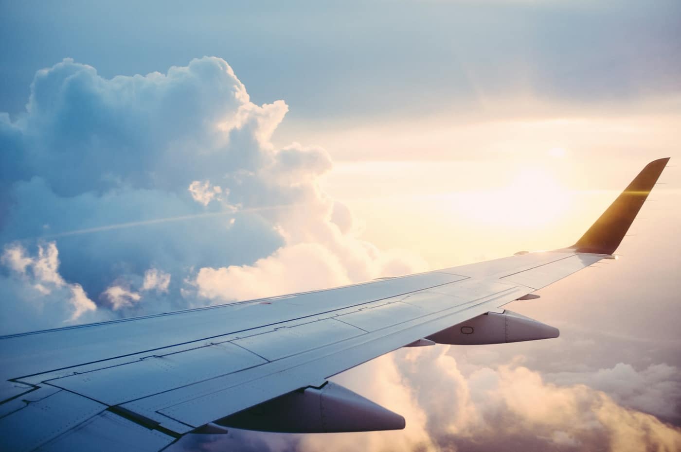 An aircraft wing above the clouds, representing air transport