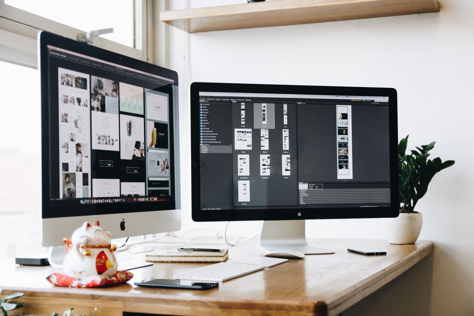 A graphics desk with website layouts on two monitors