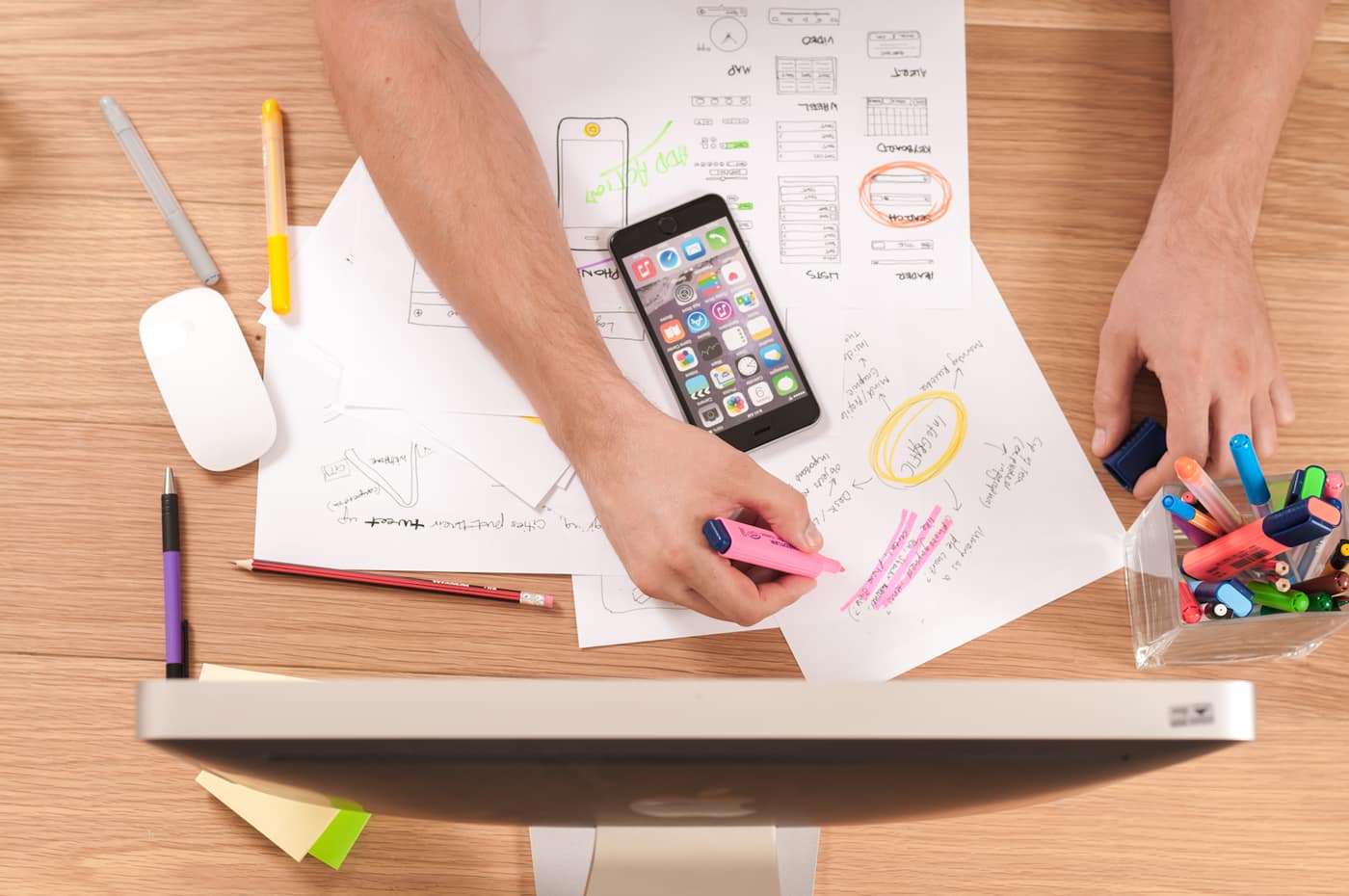 A planning session with sketches, pens and a phone on a desk